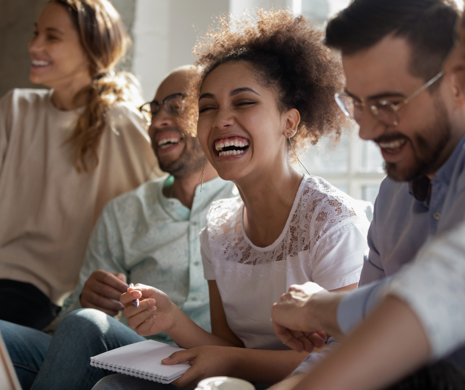 Woman laughing amongst happy coworkers
