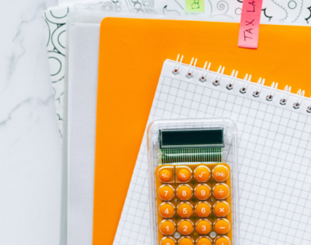 Calculator sitting on paper and notebooks