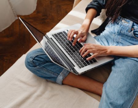 Woman sitting with laptop and typing
